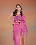 Woman wearing a pink chanderi printed saree with a black blouse against a brown background