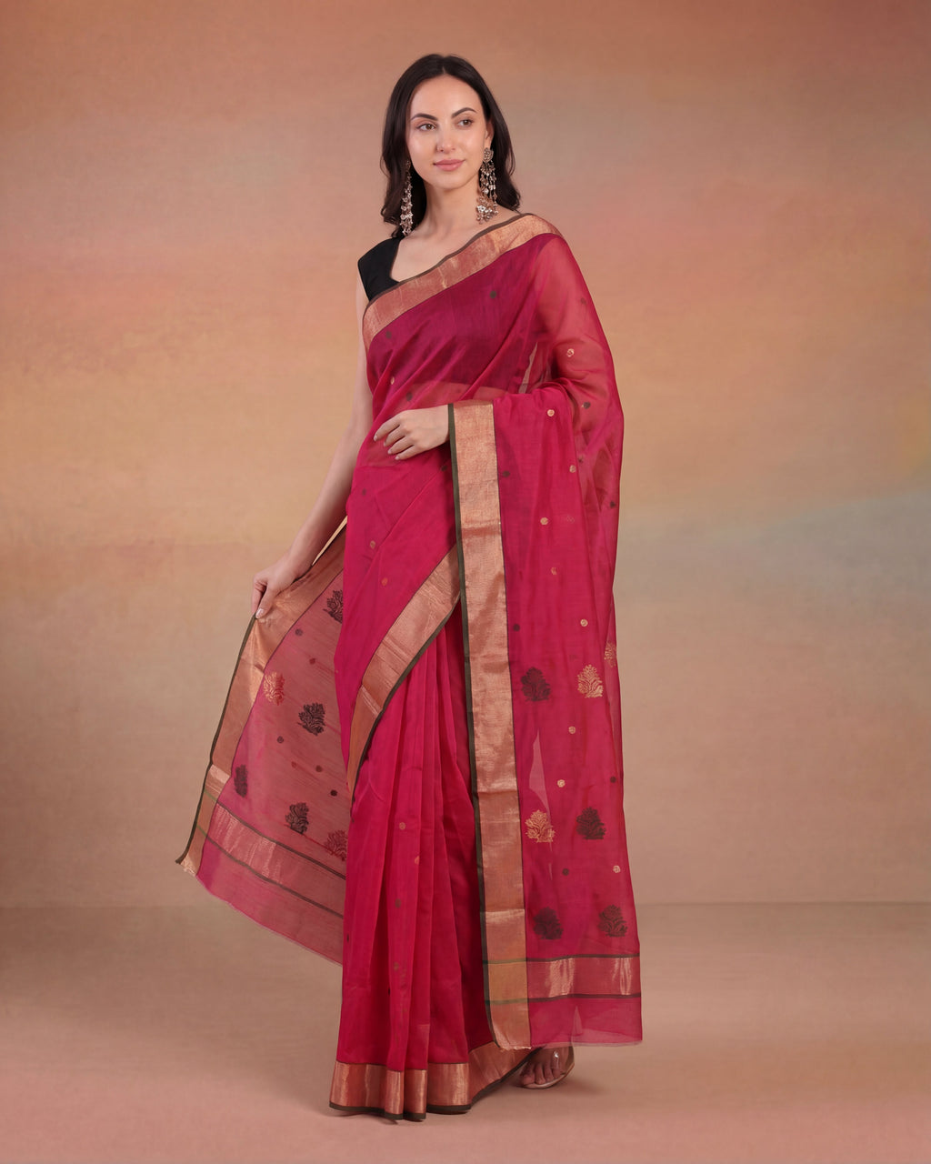Woman wearing a red chanderi silk cotton saree with a gold border against a brown background